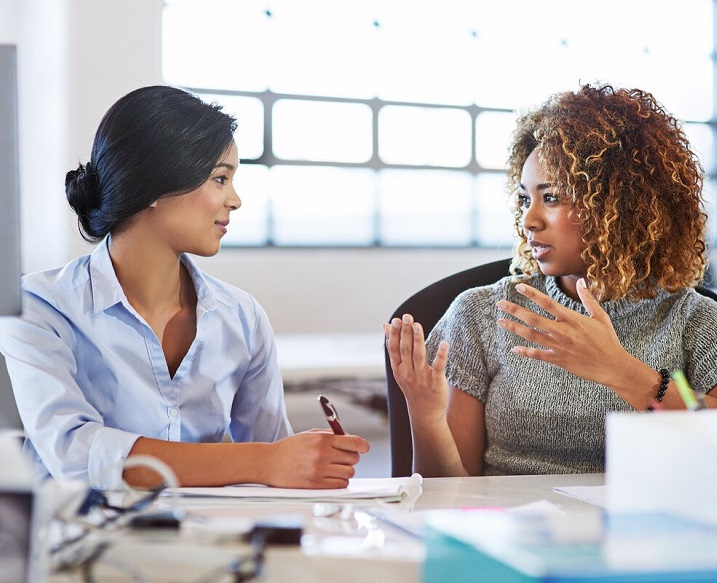 two women facing each other talking