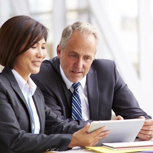 man and woman looking at tablet