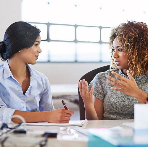 two women facing each other talking