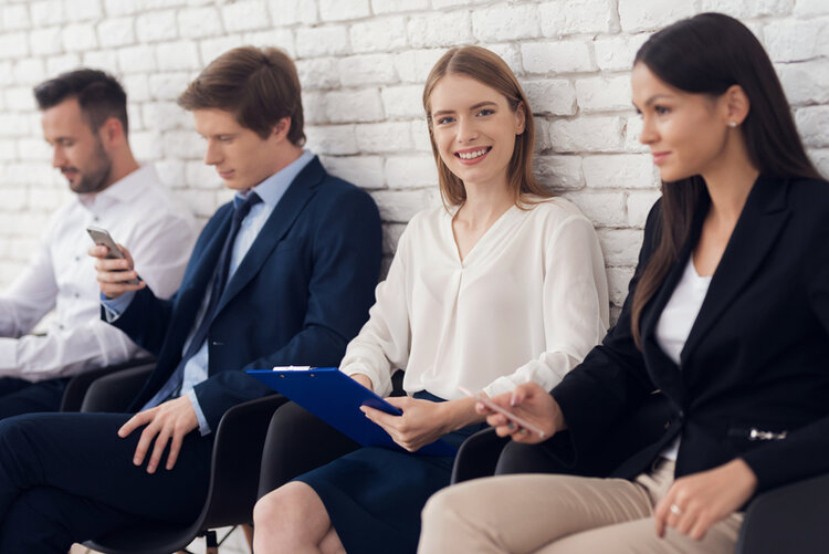 Young smiling girl in blue suit is sitting in waiting room.